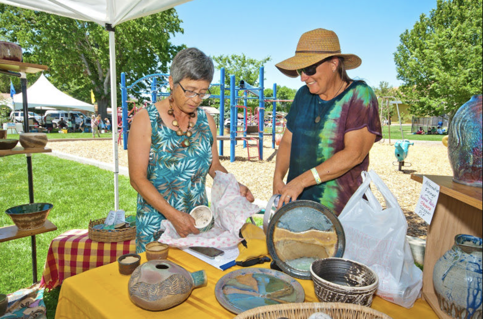 Two people shop at a ceramics booth at the Moab Arts Festival in 2018.