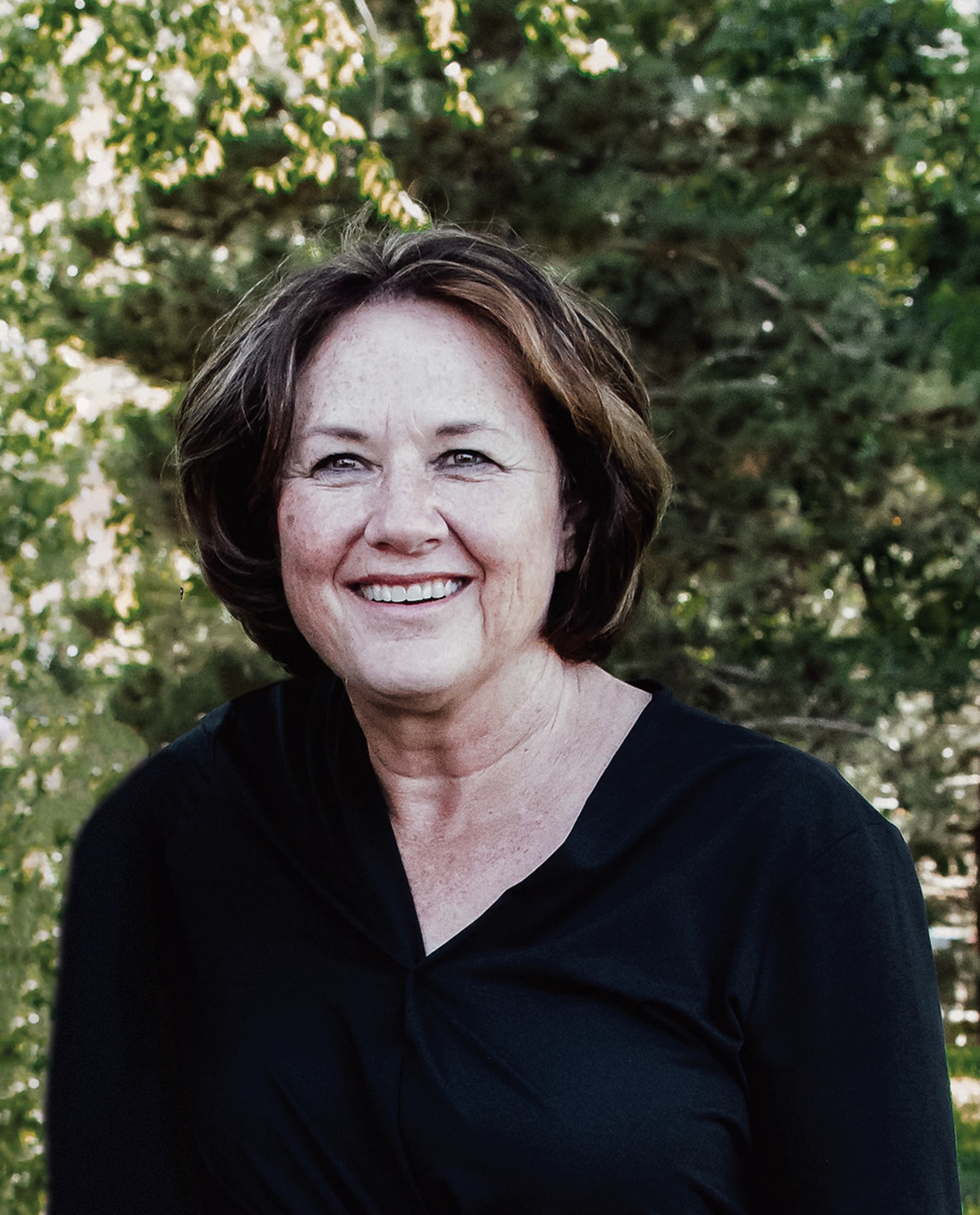 Marie is pictured outside smiling, she has a voluminous bob and is wearing a black shirt.