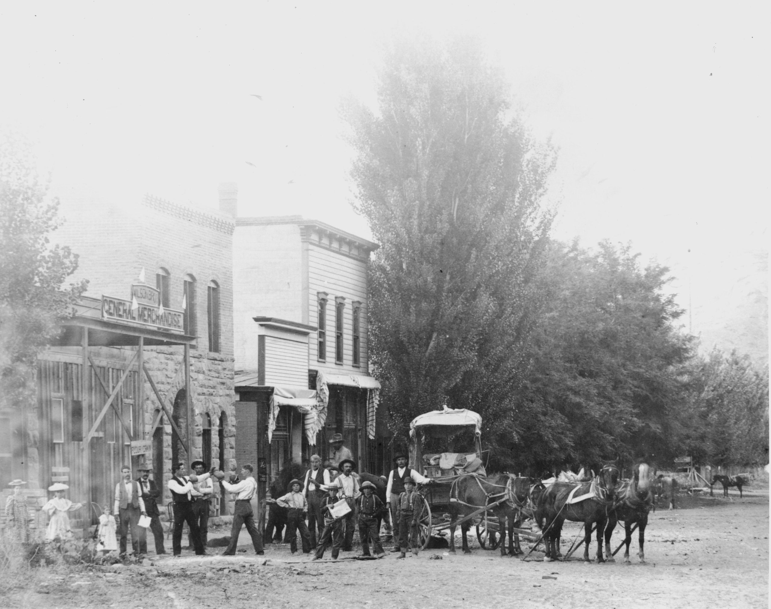 A black and white photo shows a group of people standing in front of a storefront.