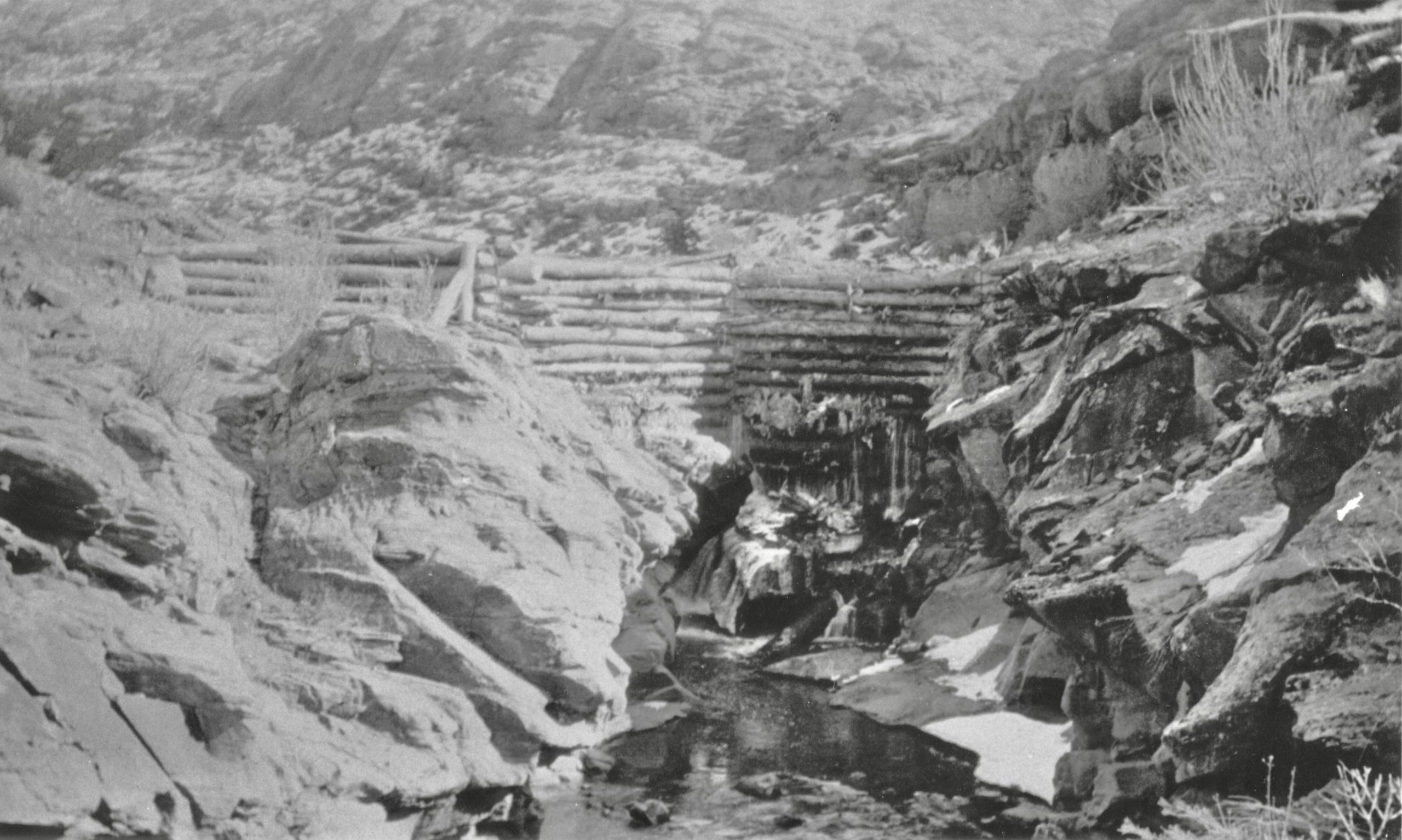 A grainy, black and white photo of a log dam at the mouth of Mill Creek.