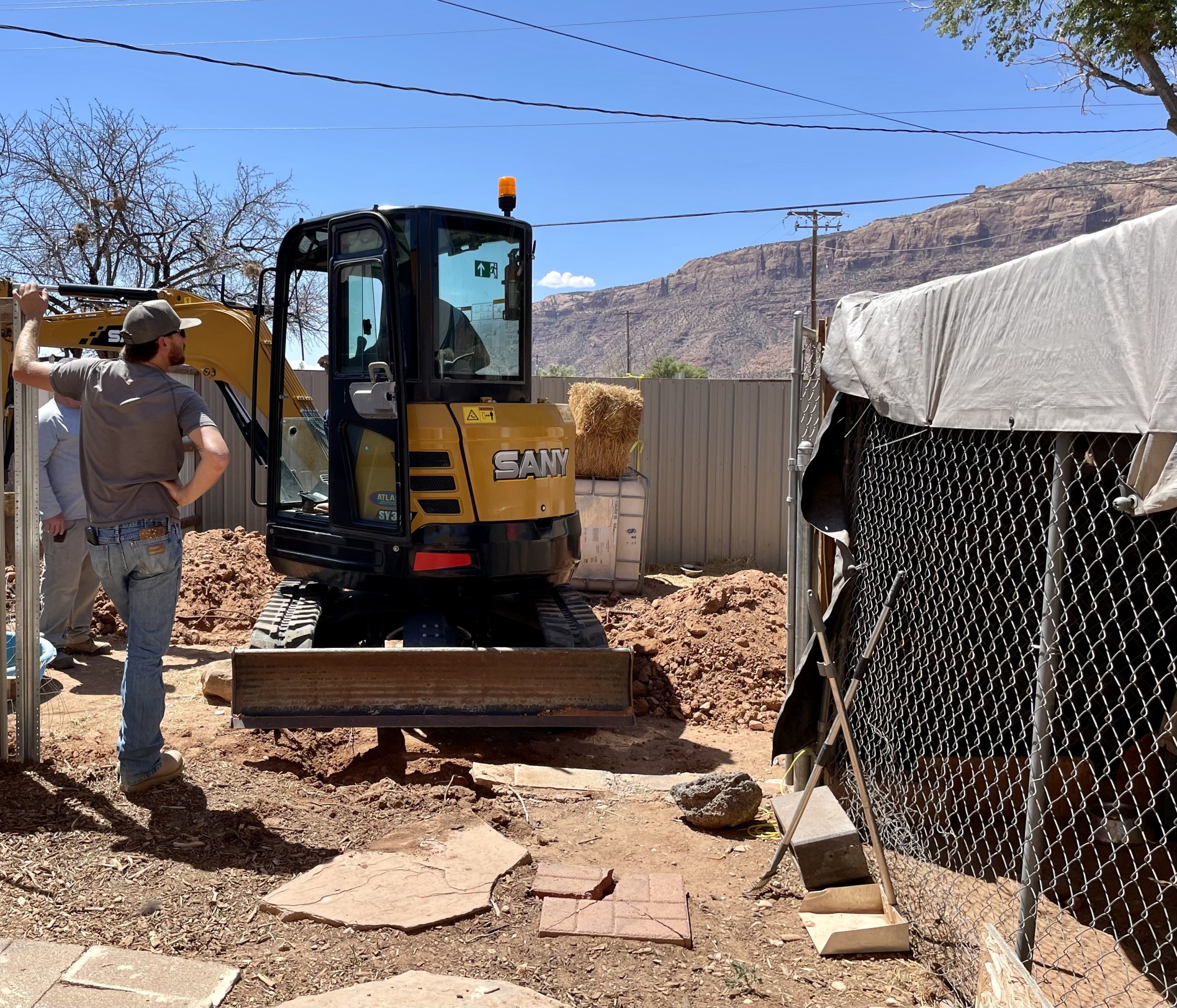 A person directs a construction machine on the Underdog campus.