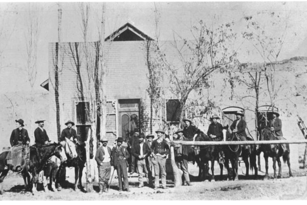 A large group of men are lined up in front of an old building.
