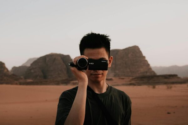 portrait of a young man with a camcorder in wadi rum jordan