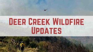 Deer Creek wildfire updates: Firefighters and helicopter on scene, smoke visible in the background.