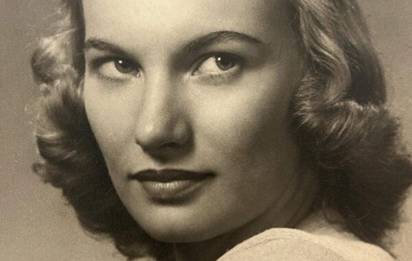 Vintage portrait of julia wilcox, a woman with wavy hair, looking back over her shoulder, in black and white.