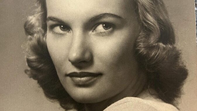 Vintage portrait of julia wilcox, a woman with wavy hair, looking back over her shoulder, in black and white.