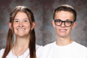 Two young individuals smiling for a portrait against a neutral background.