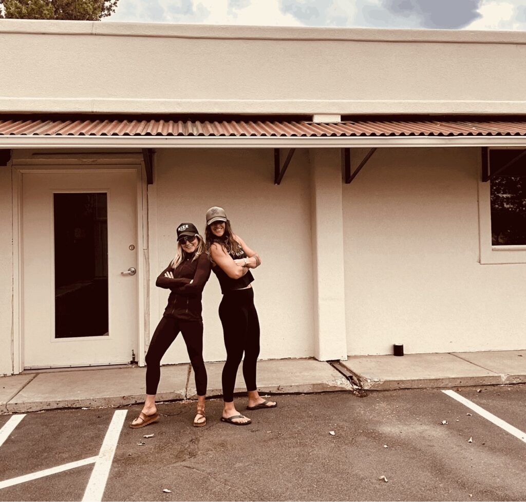 Natali Zollinger & Pam Pack posing confidently in front of Rize Training's new location.