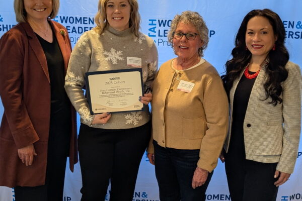 Four women posing with a certificate at the Utah Women & Leadership Project event.